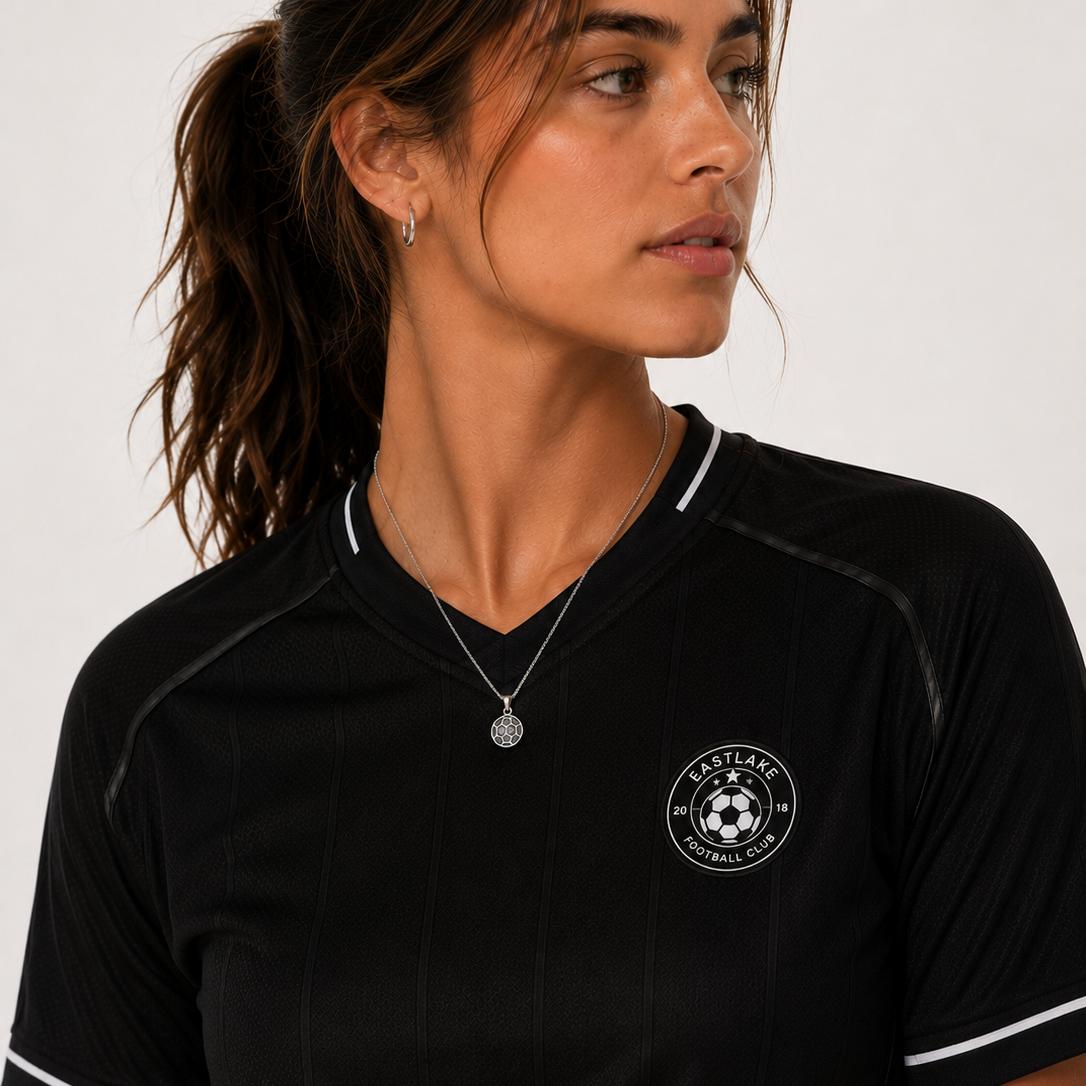 Woman wearing a black sports jersey with a logo on a white background