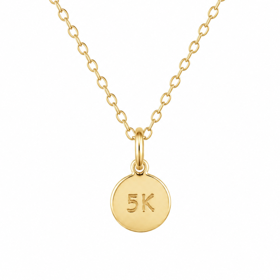 Gold necklace with a round pendant displaying '5K' on a white background
