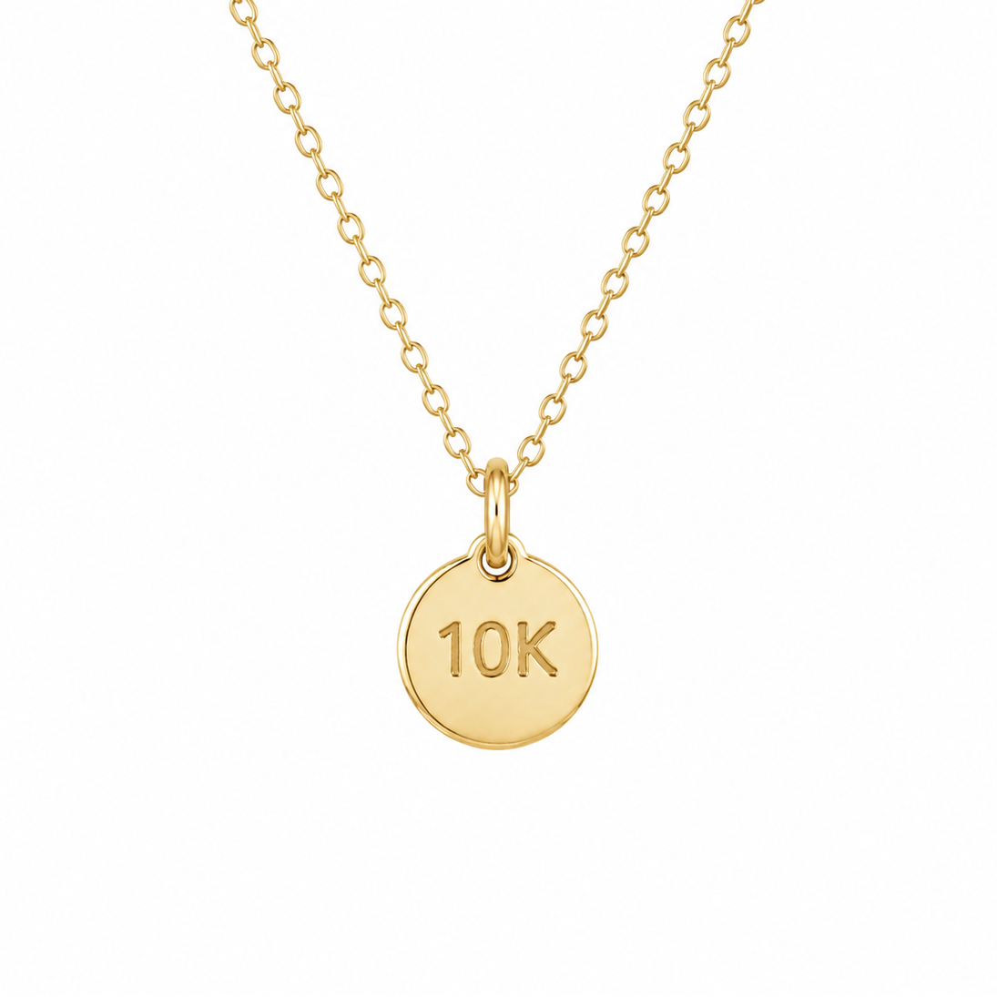 Gold necklace with a round pendant displaying '10K' on a white background