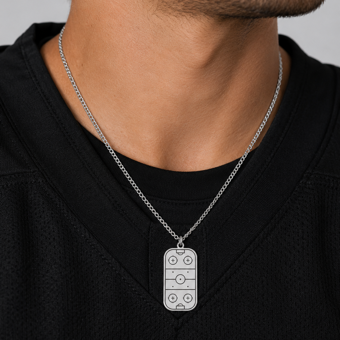 Person wearing a black shirt with a silver dog tag necklace.